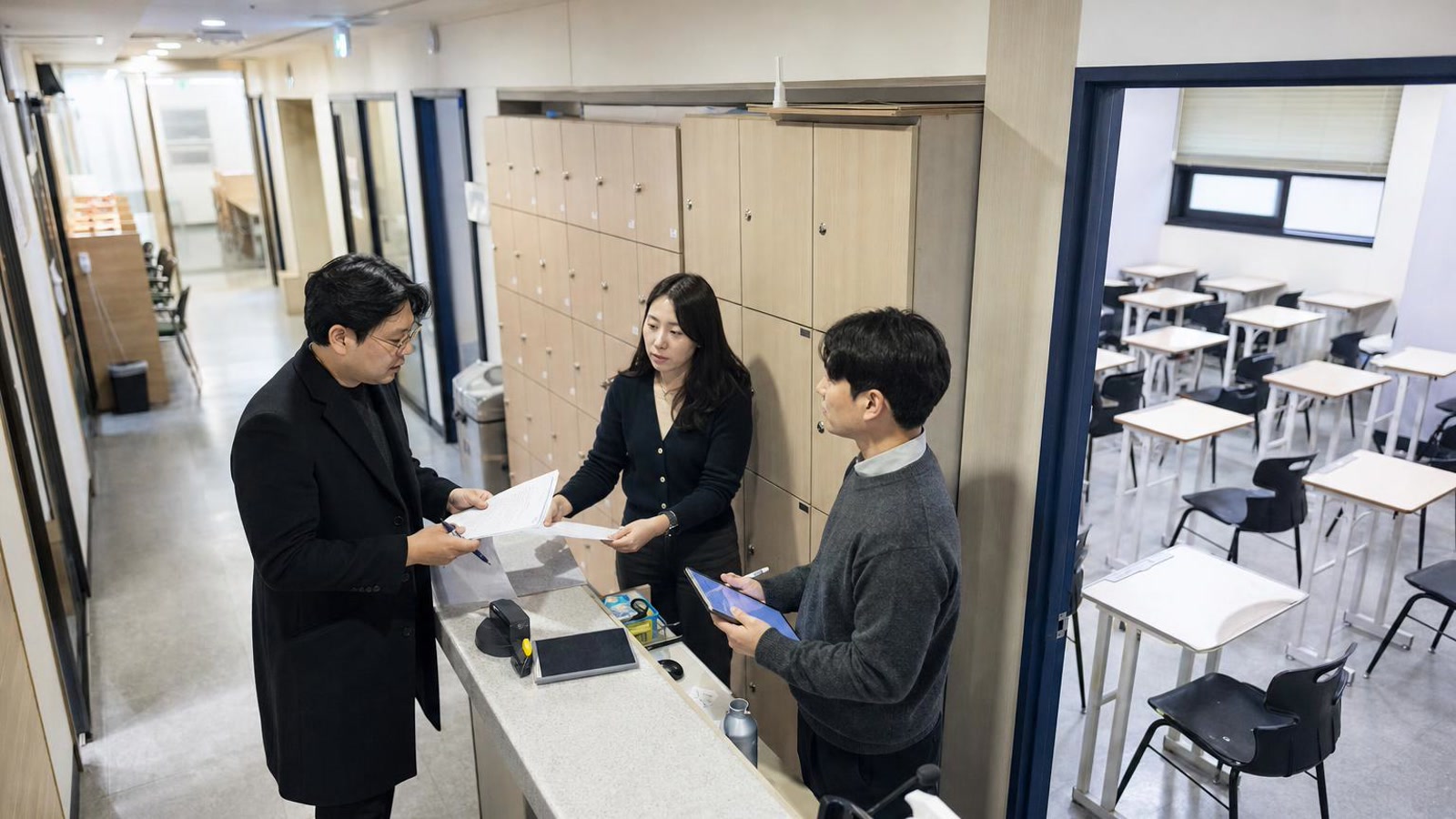 한국 학원 직원들이 상담 후속 업무를 인계하는 현실적인 사진