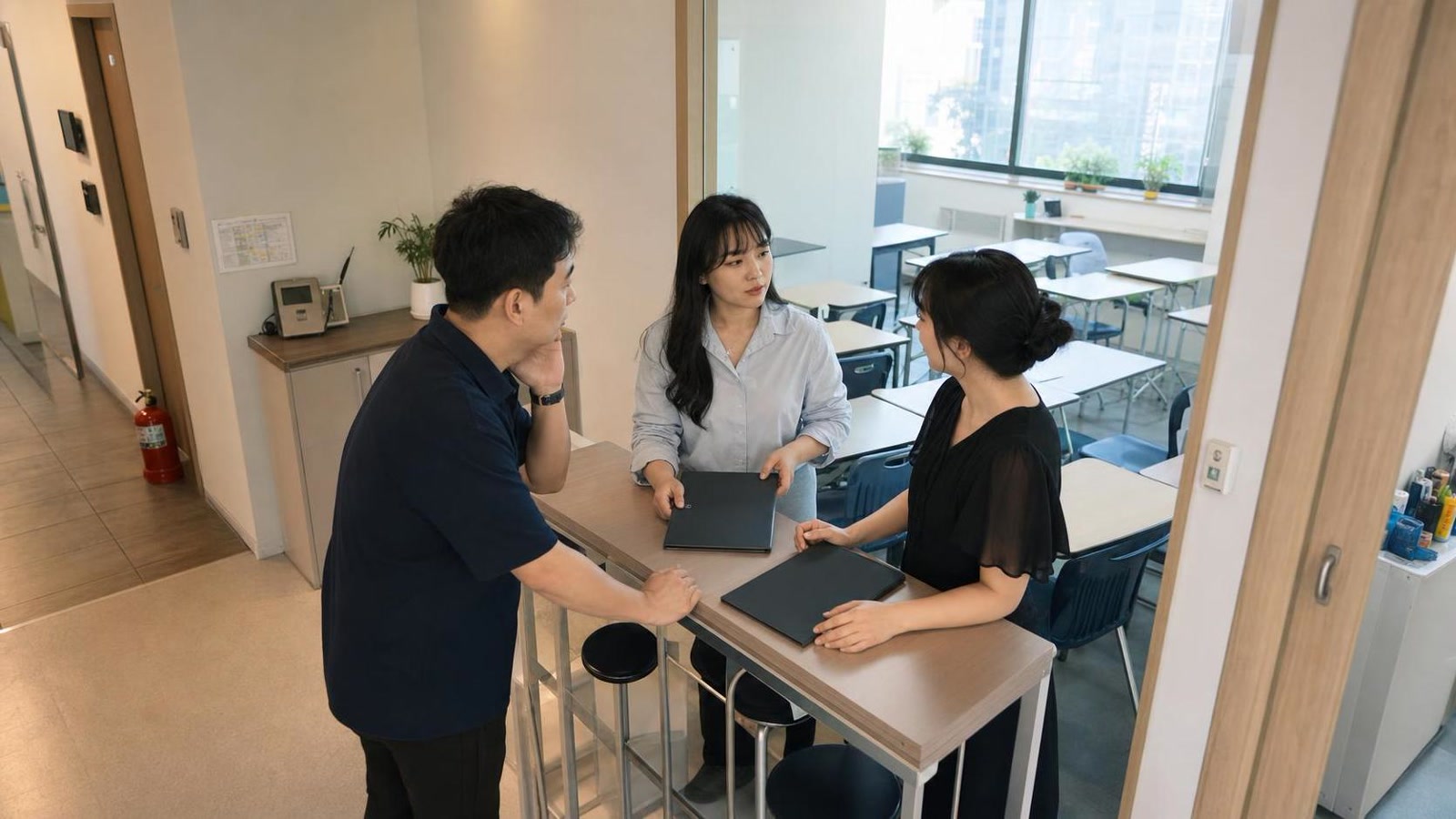 한국 학원 교무실에서 수업 전 상담 브리핑을 나누는 교직원들