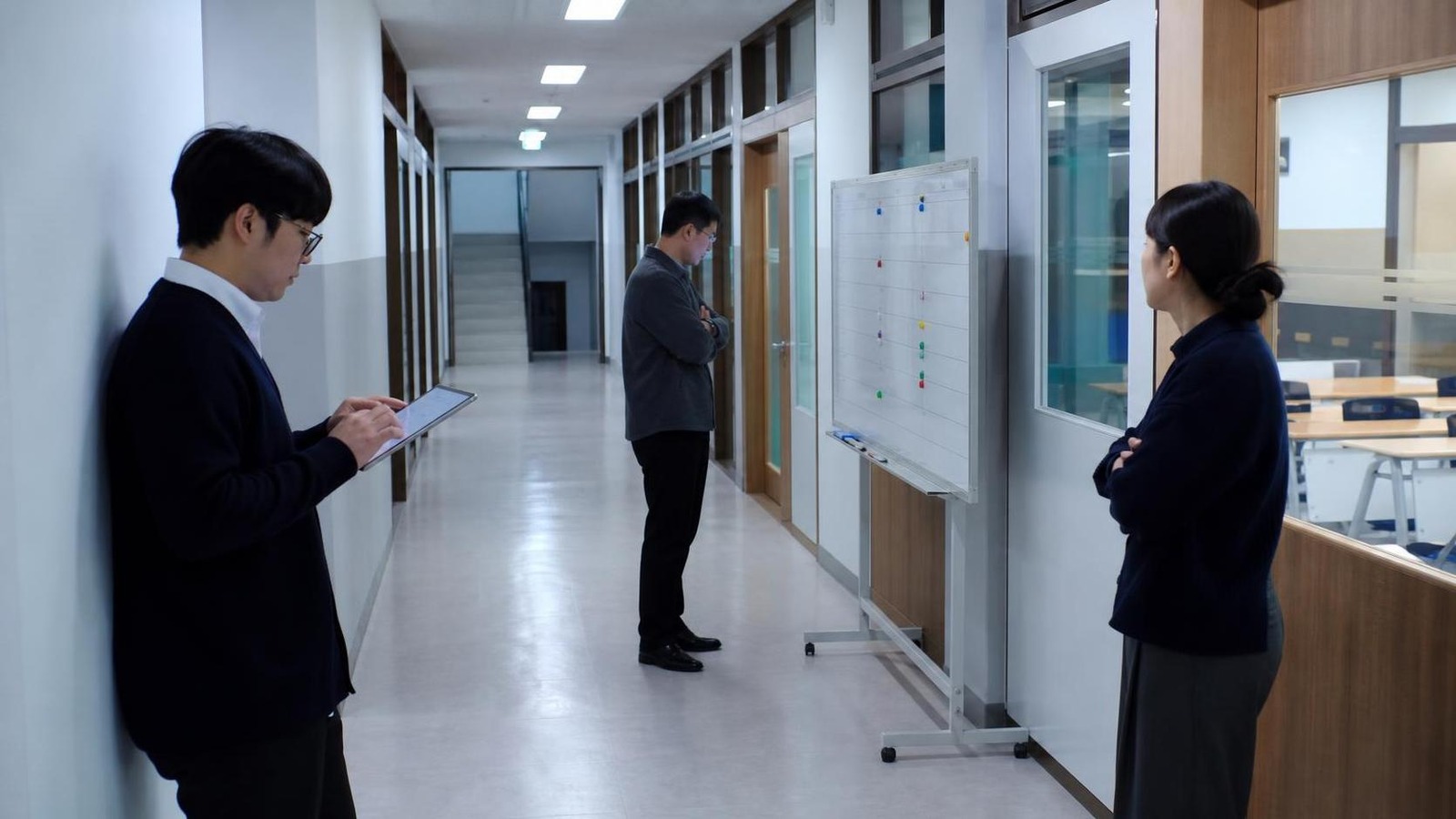 한국 학원 교실 문 앞에서 상담 후속 일정과 보강 마감을 확인하는 직원들
