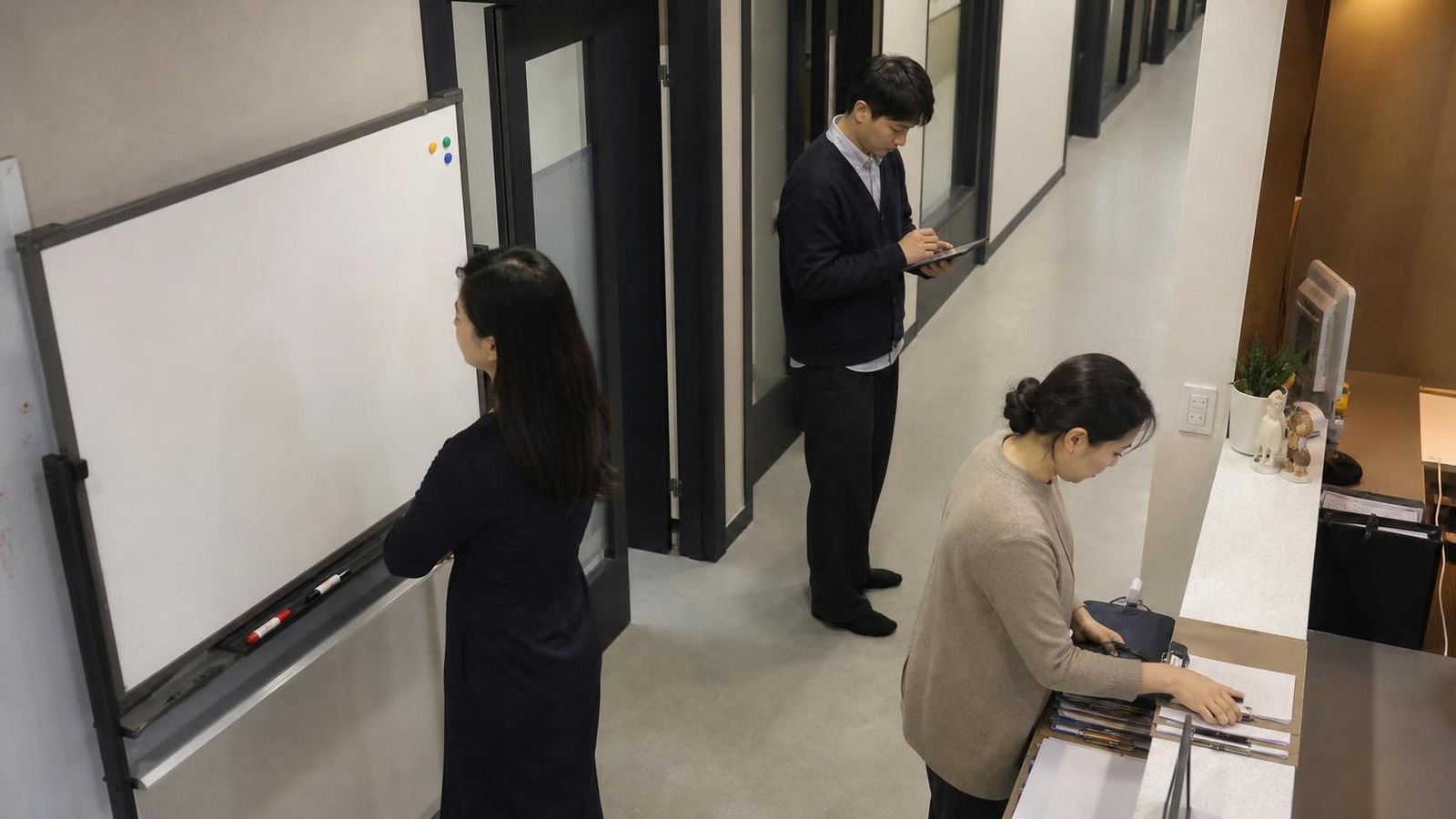 한국 학원 복도에서 상담 후 실행 담당자와 마감 시간을 확인하는 직원들