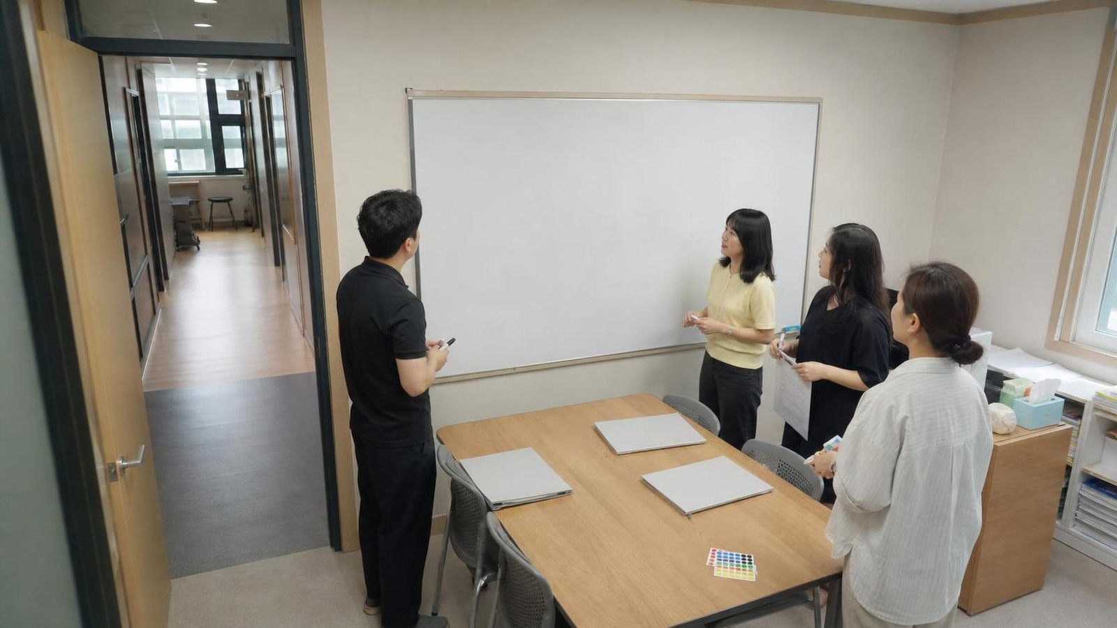 한국 학원 세미나실에서 상담 리마인드 보드를 함께 확인하는 운영진