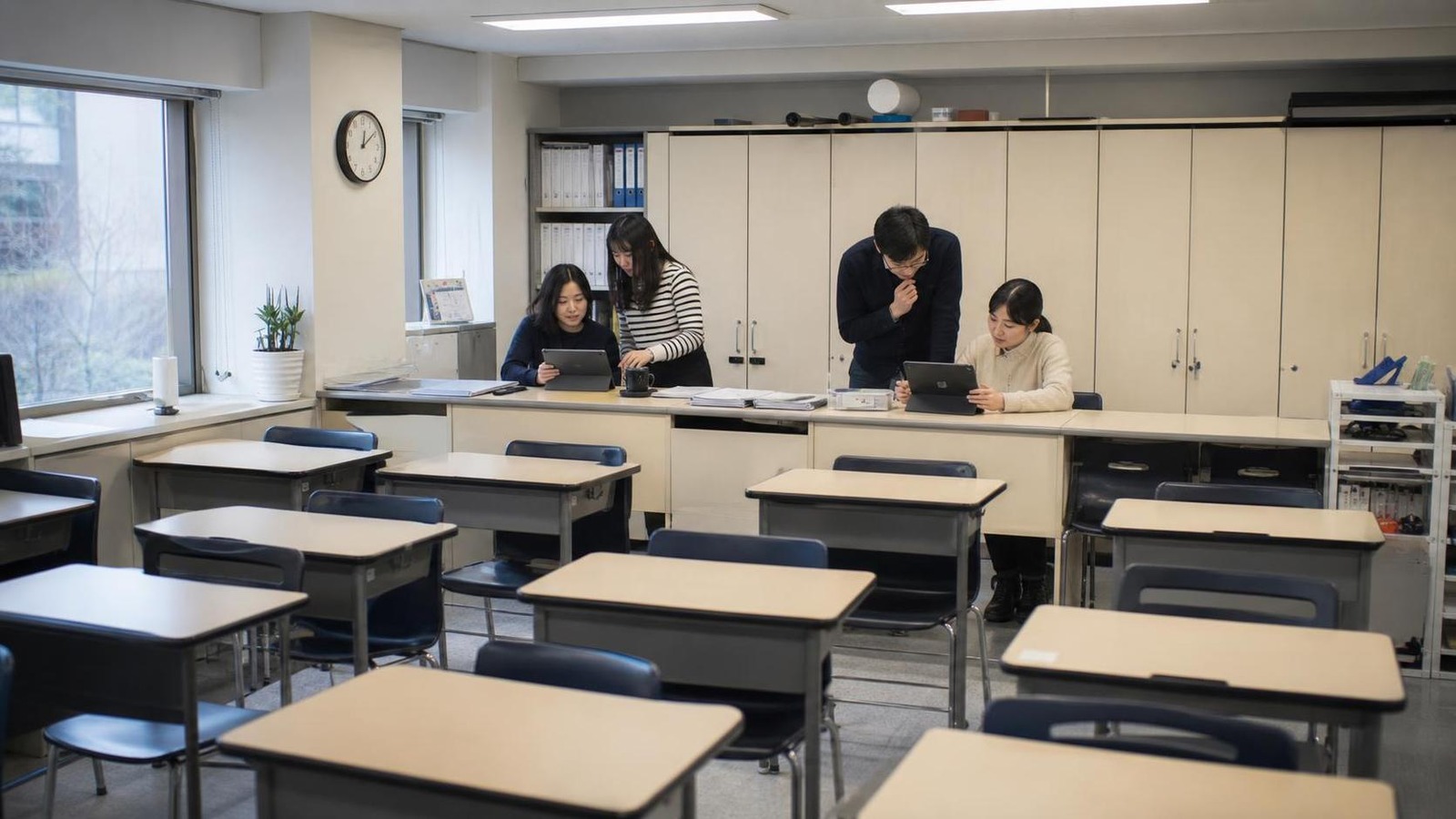 한국 학원 강의실 뒤편에서 상담 회신 상태와 보호자 안내 톤을 확인하는 직원들