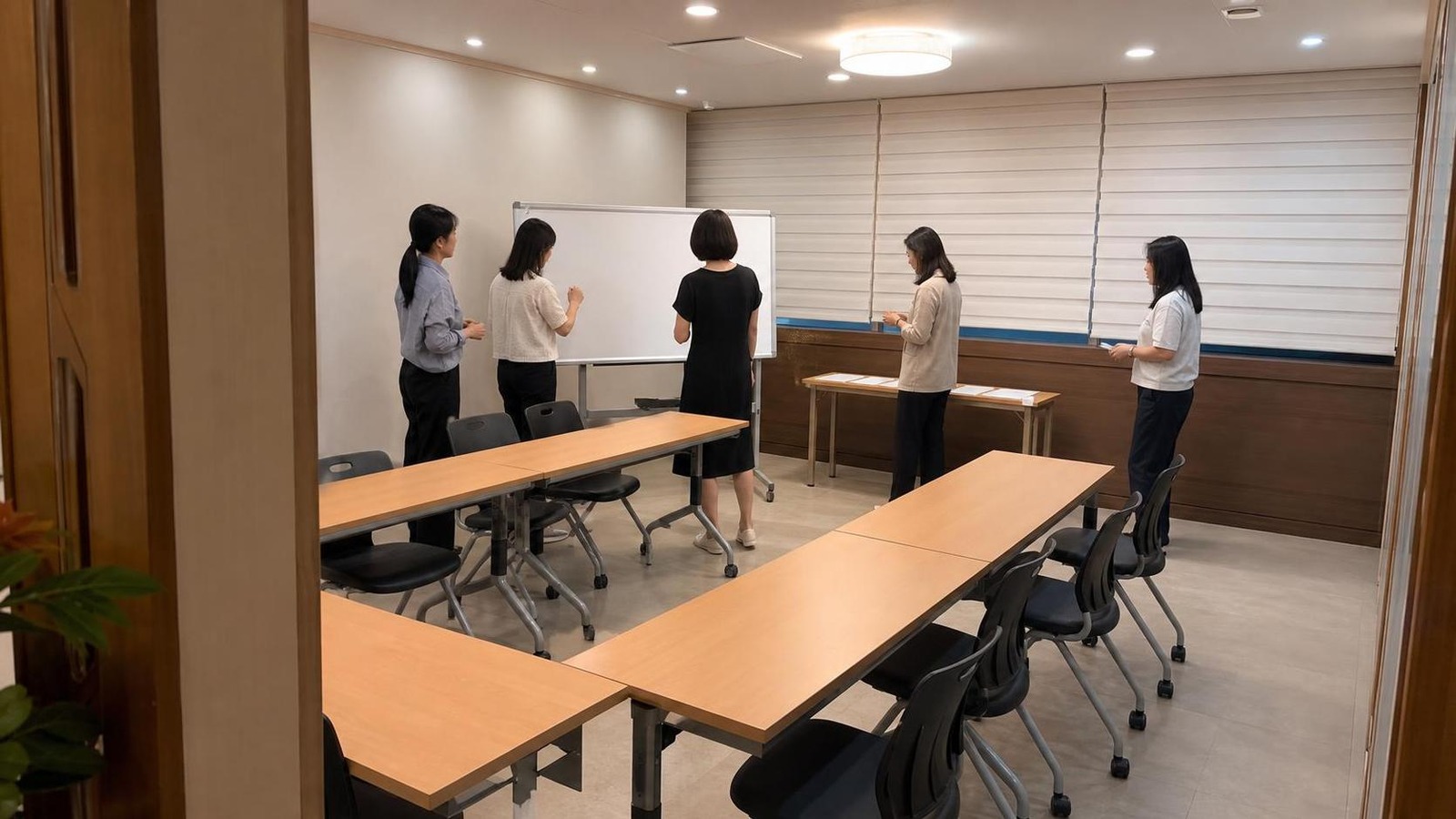 한국 학원 소형 세미나룸에서 상담 전 자료를 함께 점검하는 직원들