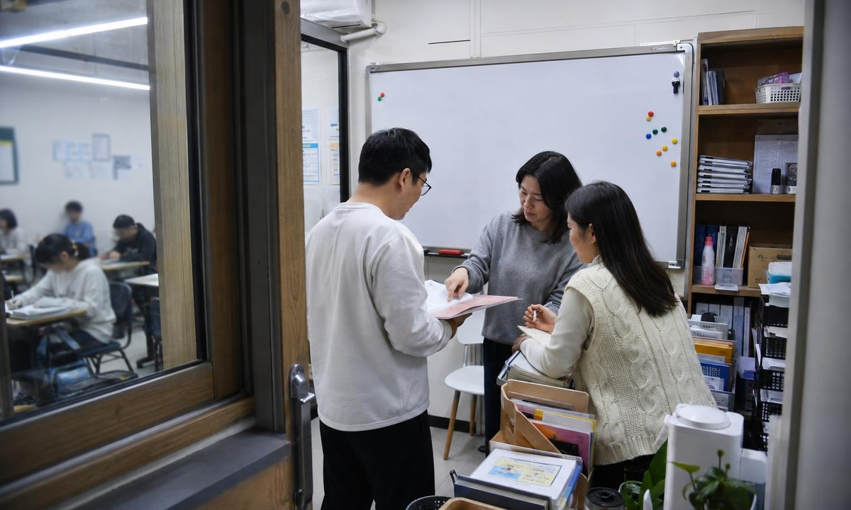 한국 학원 교사 준비실에서 상담 자료를 인계하는 실사진